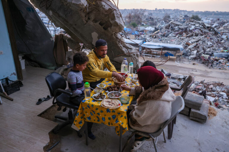 Tamer Hassan al-Shafai, 37 lat, wraz z rodziną spożywają posiłek iftar, czyli posiłek przerywający post, w zniszczonym domu pośród gruzów budynków w Beit Lahija w północnej Strefie Gazy 4.03.2025 [Zdjęcie: Bashar Taleb/AFP].