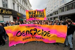 Demonstranci trzymają transparent z napisem po szwedzku „Nie dla ludobójstwa” podczas pro-palestyńskiego protestu przed drugim półfinałem Konkursu Piosenki Eurowizji w Malmö, Szwecja. Foto: Martin Meissner / AP