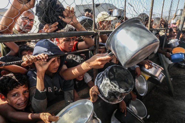 Palestyńczycy czekają na ciepły posiłek rozdawany przez organizacje pomocowe w rejonie al-Mawasi w Khan Yunis, Gaza [Foto: Abed Rahim Khatib/Anadolu]