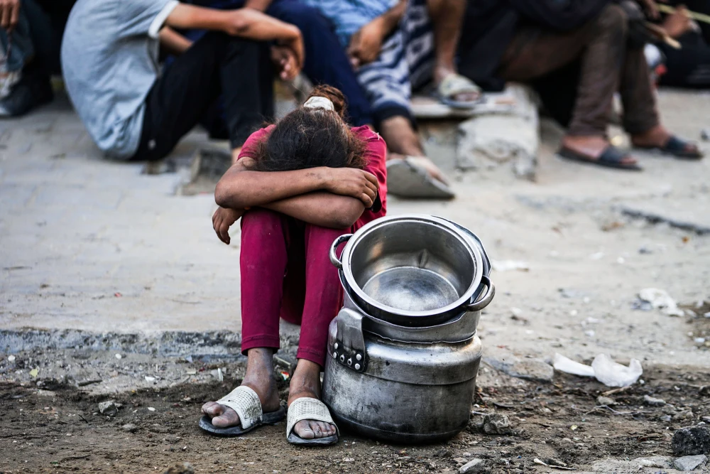 Palestyńczycy czekają na jedzenie w kuchni społecznej, Gaza City, 14 lipca. Foto: Jehad Alshrafi / AP