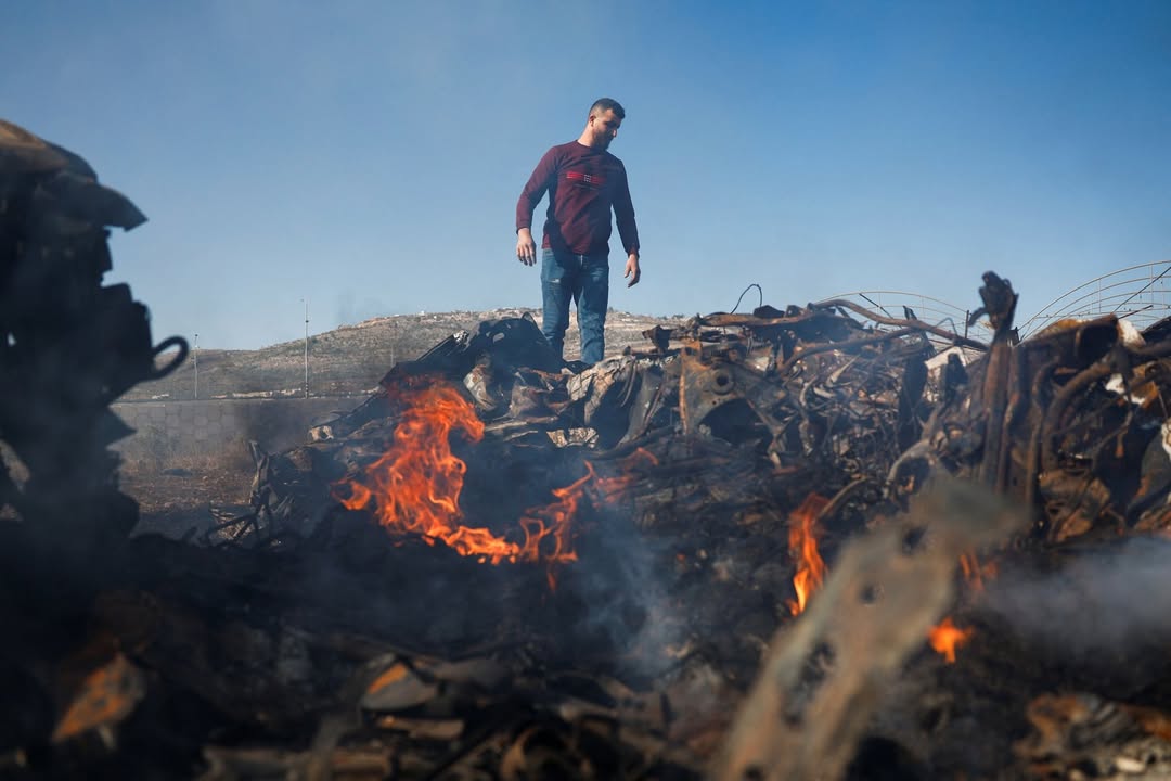 Palestyńczyk stoi obok samochodów spalonych podczas ataku izraelskich osadników w Huwarze, na izraelsko okupowanym Zachodnim Brzegu, w piątek. Foto: Ammar Awad / Reuters