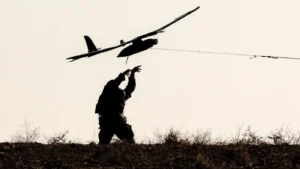 Żołnierz Izraelskich sił okupacyjnych uruchamia drona obserwacyjnego w pobliżu Strefy Gazy, 30 września 2025 roku (Foto: Jack Guez/AFP).